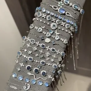 Dettaglio di vari braccialetti in zircone con pietre blu su espositore grigio