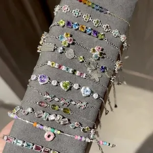 Vista dettagliata di braccialetti regolabili in zircone colorato con ciondoli a cuore e fiori