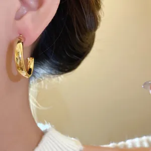Close-up view of minimalist gold waterdrop chunky hoop earrings with vintage style