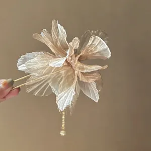Close-up of elegant champagne chiffon flower hair stick with pearl tassel