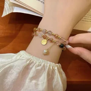 Detailed shot of an elegant multi-colored beaded bracelet with pearl and gold coin charms