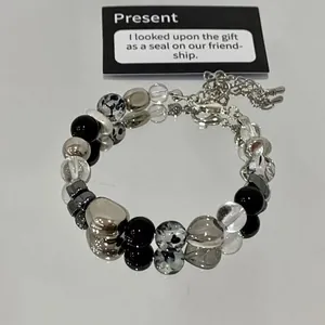 Detailed view of the beaded bracelet with heart patterns on a reflective mirror.