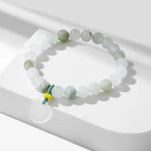 Detail showing translucent heart pendant and natural pale green beads on bracelet