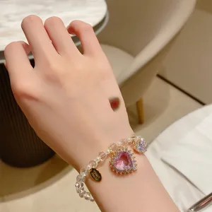 Macro view of a crystal beaded bracelet with a sparkling pink heart-shaped charm detail.
