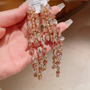 Dettaglio di orecchini a nappa con cristalli marquise rosa e bianchi scintillanti