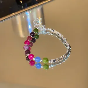 Detailed close-up of colorful crystal round beads and silver rectangular metal spacers.