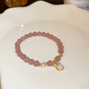 Detail view of pink crystal beaded bracelet with cute gold-rimmed rabbit pendant