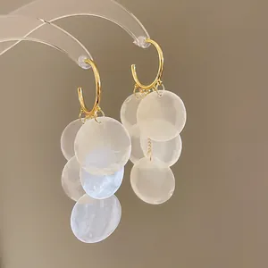 Boucles d'oreilles créoles dorées avec grappes de disques en nacre blanche pour l'été