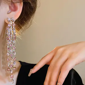 Dettaglio di eleganti orecchini lunghi a nappa con cristalli rosa e trasparenti