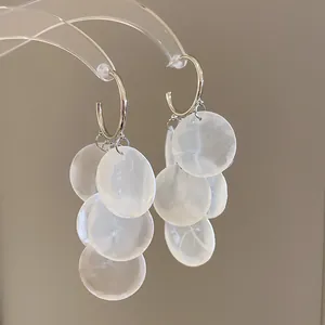 Boucles d'oreilles créoles argentées avec disques en pierre d'œil de chat blanc translucide.