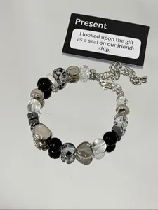 Close-up detail of a stylish beaded bracelet featuring clear crystals and a silver heart bead