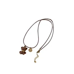 Collana con ciondolo a forma di orsetto floccato e fiocco dorato con cordino marrone