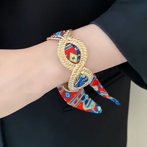 Close-up of a French exotic alloy bracelet with a vibrant printed scarf ribbon detail