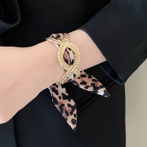 Detailed view of a French vintage gold alloy bracelet featuring a leopard print silk ribbon scarf