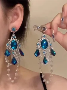 Detailed view of vintage palace style dangling earrings featuring blue crystals and white pearls