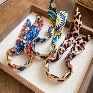Detailed view of three vintage alloy cuff bracelets with colorful silk scarves and leopard prints.