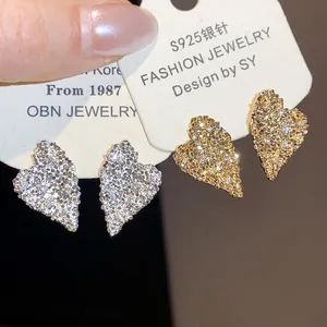 Primo piano di eleganti orecchini a lobo a forma di cuore con pietre di zircone