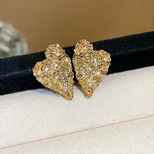 Dettaglio orecchini a cuore testurizzati placcati oro 18K con zirconi brillanti incastonati