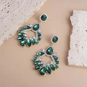 Detailed view of emerald green and clear crystal teardrop dangling earrings for women.
