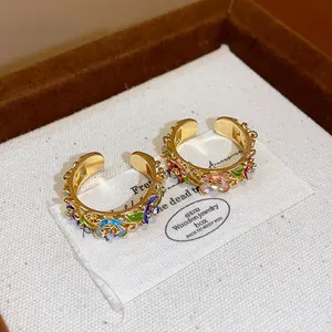 Detailed view of 18k gold plated enamel flower rings with sparkling rhinestones