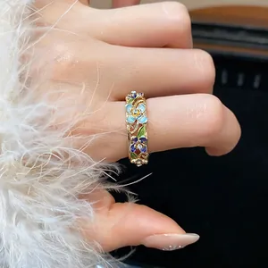 Close-up of 18k gold plated floral enamel open ring with shimmering diamond accents.