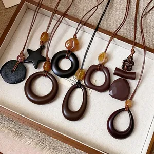 Collana etnica retrò in resina con vari ciondoli geometrici su cordino marrone
