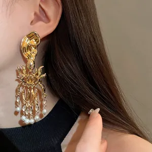 Macro detail of a vintage gold-toned geometric earring with crystals and pearls