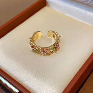 Close-up of 18k gold plated floral open ring with enamel petals and rhinestones.
