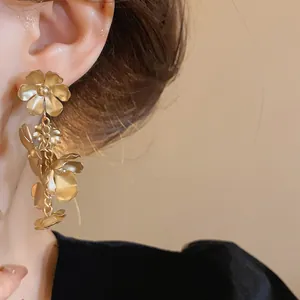 Gros plan détaillé montrant des boucles d'oreilles vintage à pampilles de fleurs.