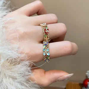 Close-up of 18k gold-plated ring featuring colorful enamel flowers and sparkling rhinestones