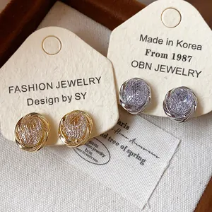 Detail of 18k gold and silver plated geometric zircon clip-on earrings on cards