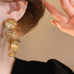 Gros plan détaillé de boucles d'oreilles vintage en forme de fleurs portées par un modèle