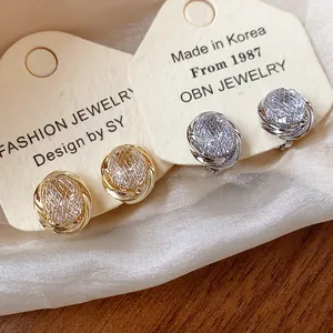 Detailed view of elegant gold and silver geometric zircon ear clips on jewelry display cards.
