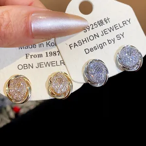 Close-up of 18k gold plated zircon geometric clip-on earrings in gold and silver finishes