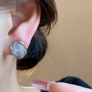 Close-up view of a sparkly silver zircon geometric ear clip worn on a model's ear
