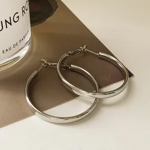 Detaillierte Nahaufnahme minimalistischer silberner Creolen mit glänzendem Finish
