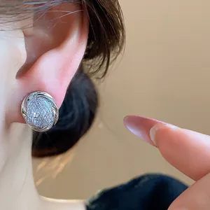 Close-up view of elegant silver round geometric clip-on earring with sparkling pavé zircon stones