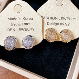 Close-up of 18k gold plated zircon geometric ear clips on jewelry cards