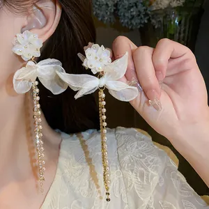 Detail macro view showing the elegant white flower design with long pearl tassel dangles