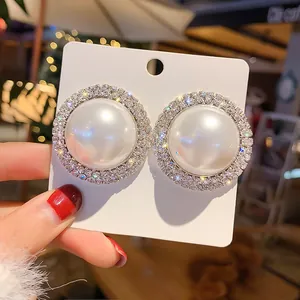 Élégantes boucles d'oreilles rondes avec perle blanche et halo de strass