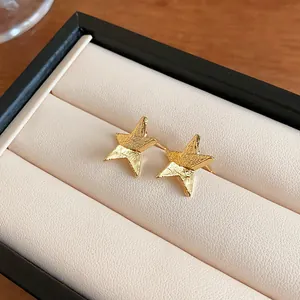 Textured gold hammered star stud earrings displayed in a luxury cream jewelry box