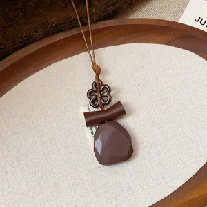 Dettaglio macro di una collana etnica in resina con pendenti geometrici retrò