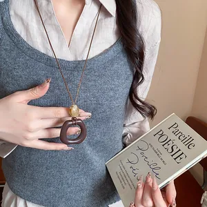 Primo piano di una collana vintage in resina con pendente geometrico marrone scuro