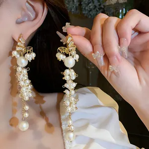 Elegant long pearl tassel earrings with golden butterfly accents and sparkling crystal details