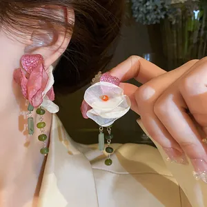Close-up of elegant fabric flower tassel earrings with pink heart and green beads