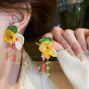 Detailed close-up of vibrant floral tassel earrings with fabric petals and heart charm
