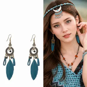 Vintage bohemian tassel earrings with teal feathers and intricate bronze filigree details