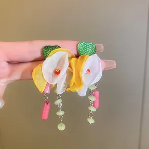 Detail view of colorful floral tassel earrings with fabric petals and beaded drops