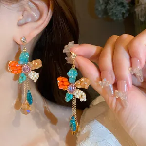 Close-up view of colorful flower tassel earrings with elegant pearls and crystal drops