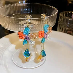 Elegant detail shot of colorful beaded flower earrings with pearl and crystal tassels
